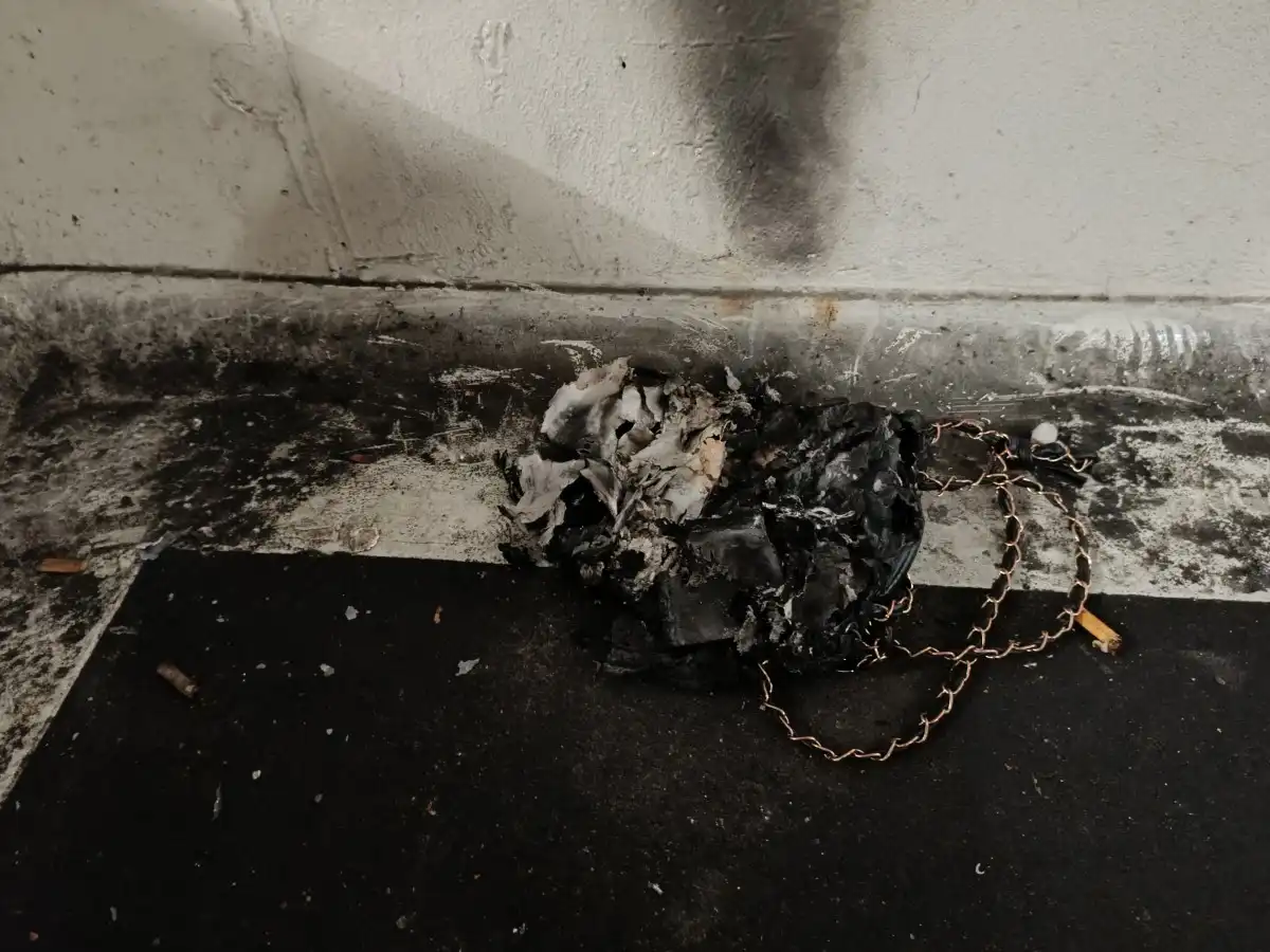 Schwarzes, verbranntes Material auf Boden